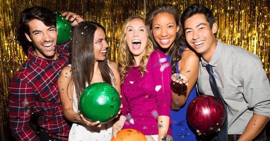 people laughing and holding bowling balls